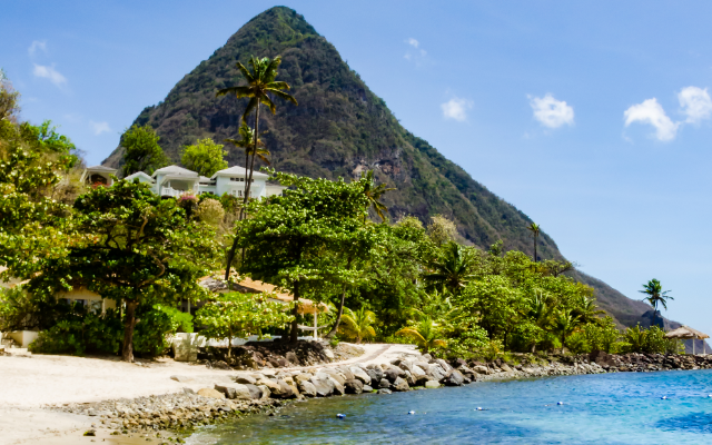 A looming volcanic piton in St Lucia surrounded by turquoise ocean