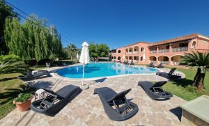 Aronda House in Corfu Greece, with a swimming pool and lounge chairs.