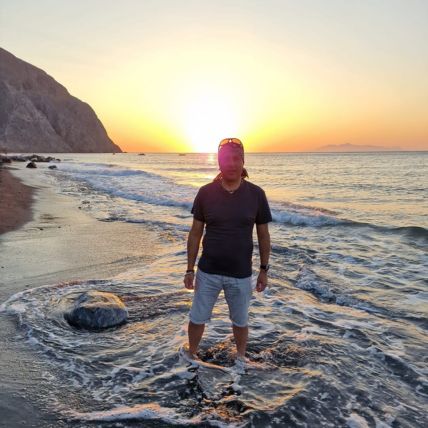 Dr Ajay poses in the sea on a beach