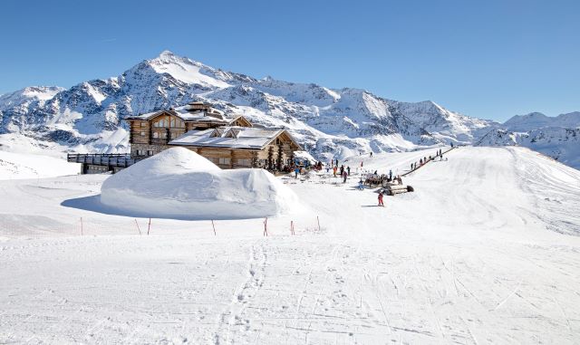 Downhill slope and apres ski mountain hut with restaurant terrace in the Italian Alps, Europe, Italy. Ski area Santa Caterina Valfurva