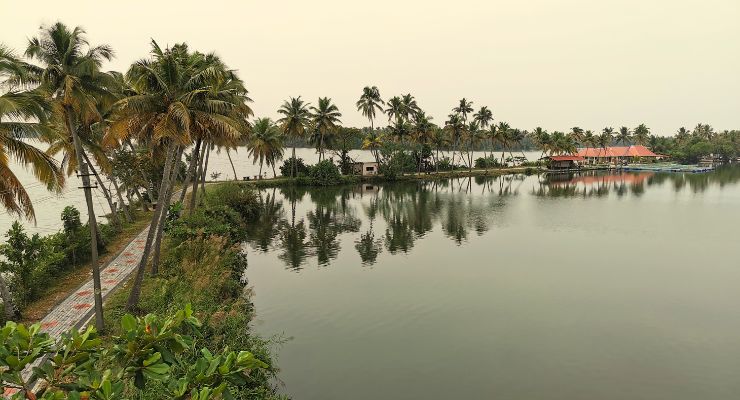 A boat guilds across Vembanad Lake India.