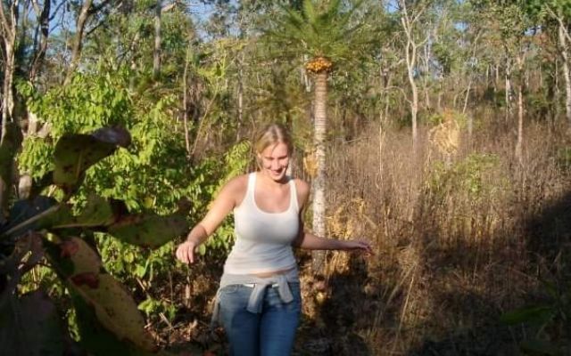 woman walking through forest smiling